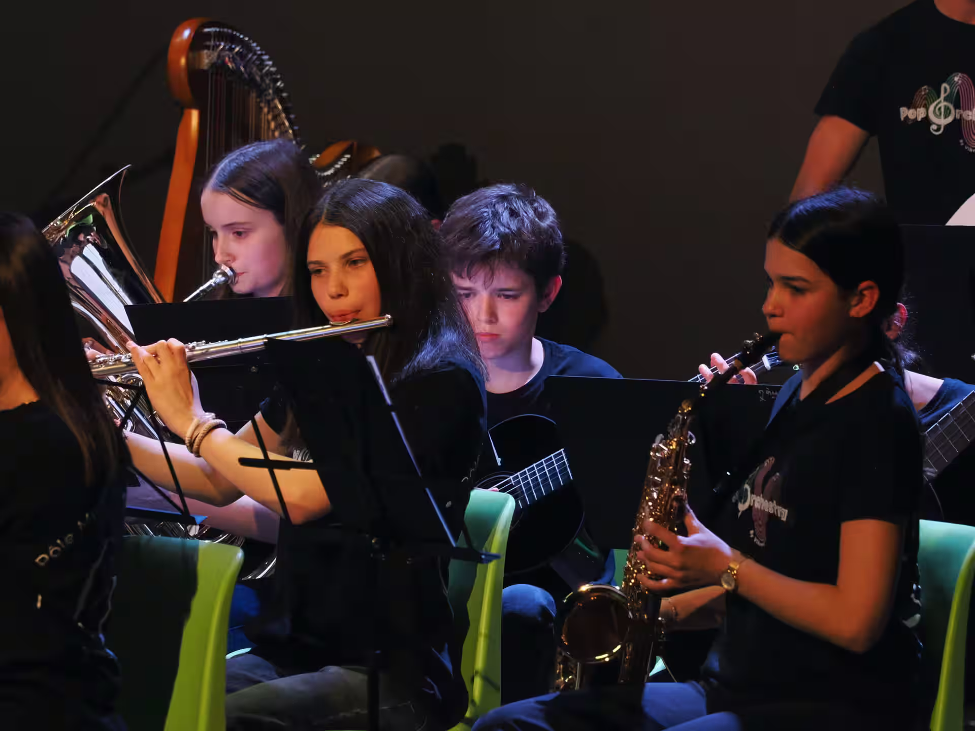 Ensemble d'élèves jouant trompette, flûte, guitare et saxophone lors d'un concert